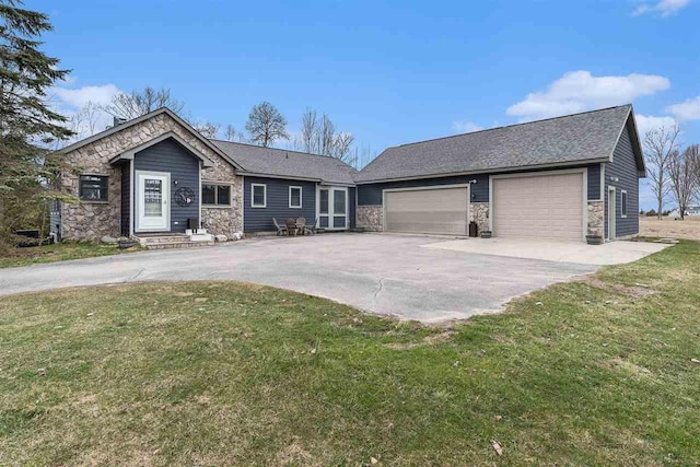 ranch-style house featuring a front lawn, concrete driveway, and stone siding