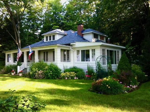 view of front facade with a front lawn and a chimney