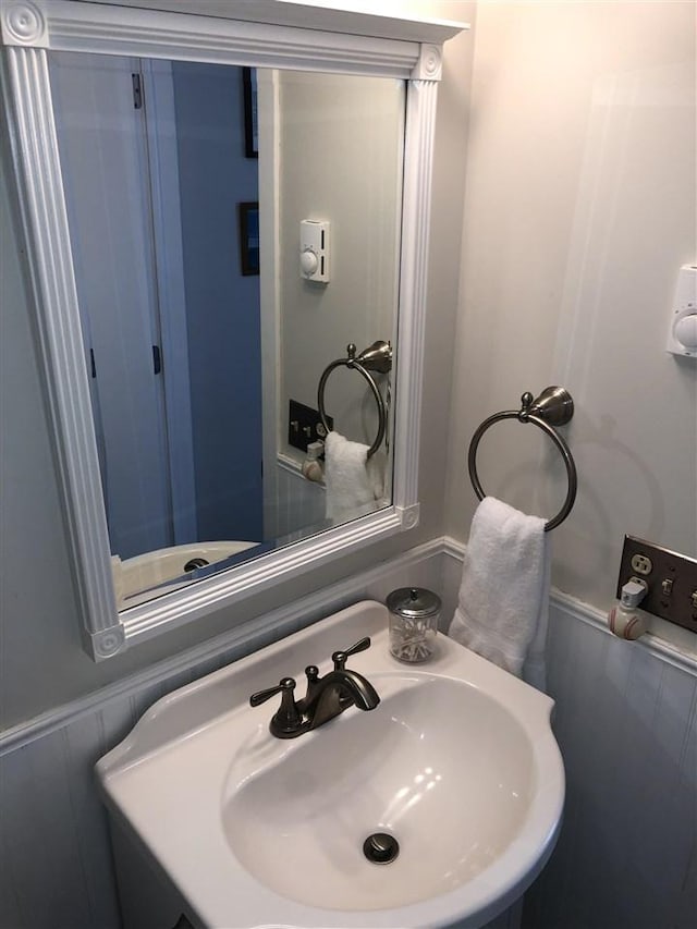 bathroom featuring a wainscoted wall and a sink