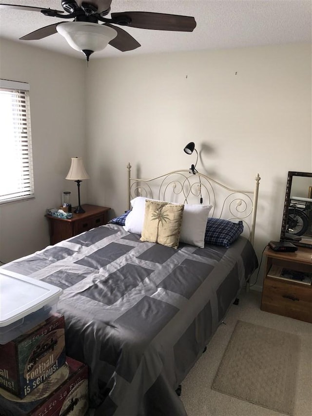 bedroom with a textured ceiling, carpet floors, and ceiling fan