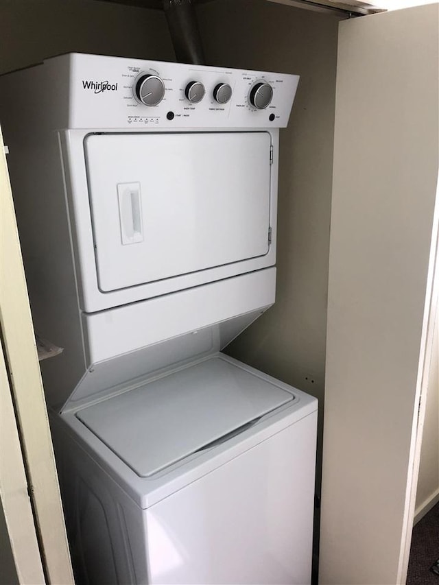 laundry room featuring stacked washer / drying machine