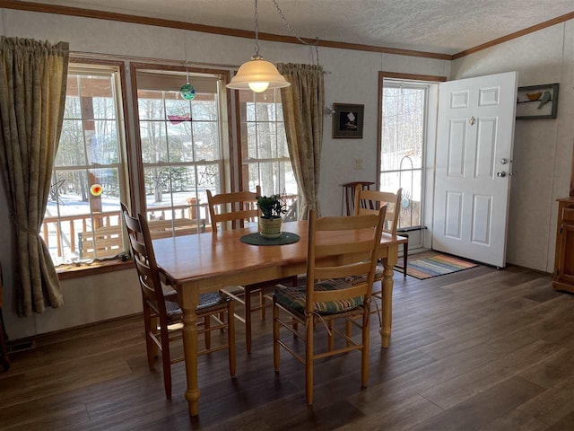 dining space with a textured ceiling, crown molding, and wood finished floors