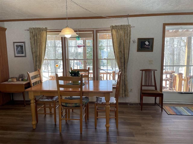 dining area featuring ornamental molding, wood finished floors, and a textured ceiling