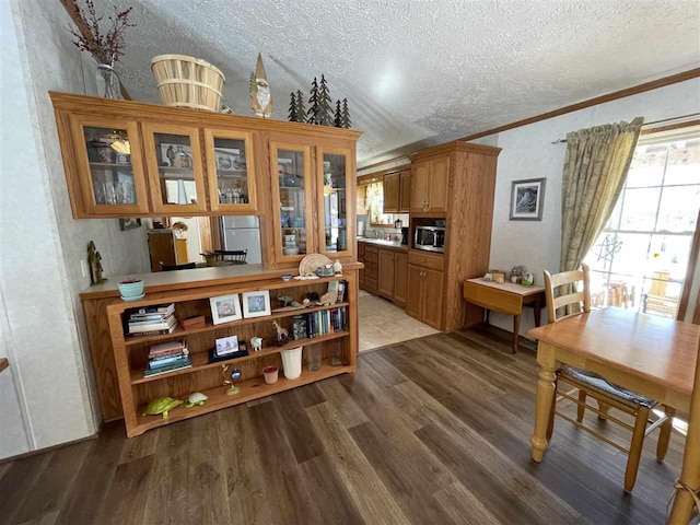 dining area with a textured ceiling, crown molding, and wood finished floors