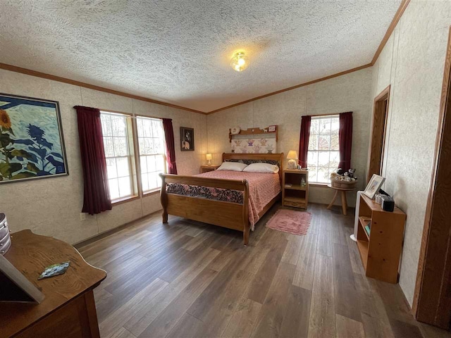 bedroom featuring crown molding, vaulted ceiling, wood finished floors, and a textured ceiling