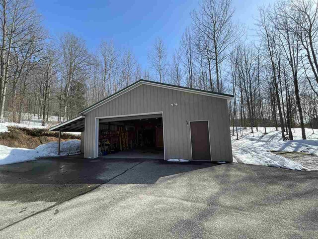 snow covered garage featuring a garage