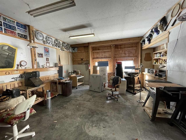 misc room with unfinished concrete floors, a workshop area, and a textured ceiling