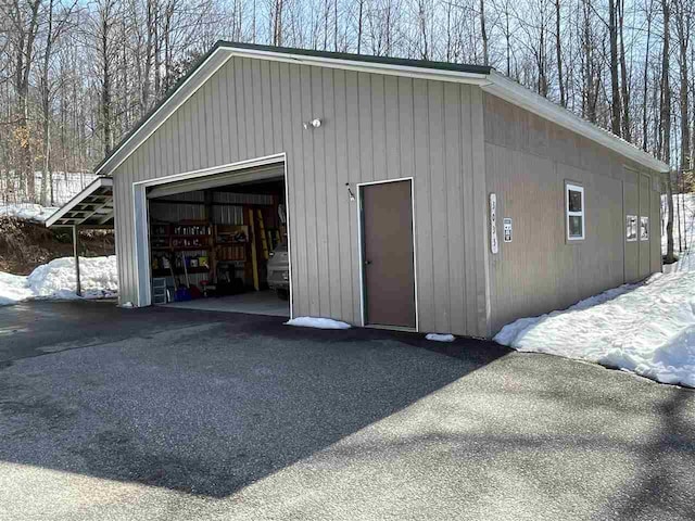 snow covered garage featuring a garage