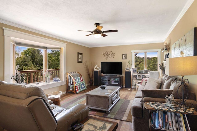 living room with baseboards, a ceiling fan, wood finished floors, and crown molding