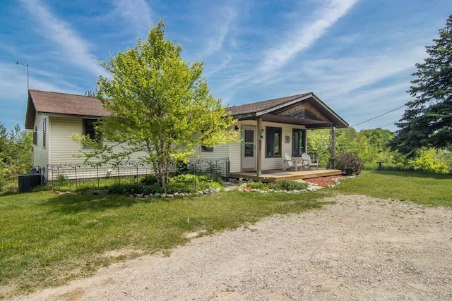 rear view of house featuring a yard, central AC unit, and a porch