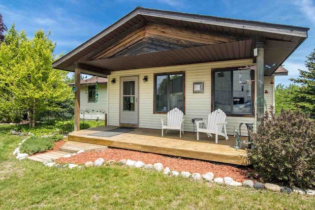 rear view of property with a deck and a lawn