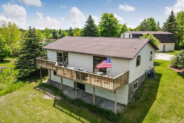 back of house featuring a shingled roof, a yard, central AC, and a wooden deck