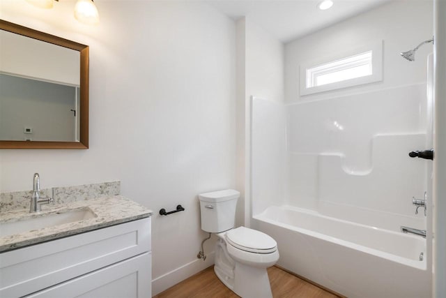 full bath with vanity, wood finished floors, baseboards, toilet, and shower / bathtub combination