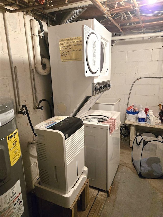 washroom with laundry area, water heater, and stacked washer and clothes dryer