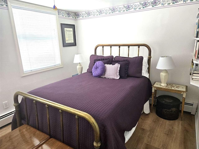 bedroom featuring wood finished floors and a baseboard radiator