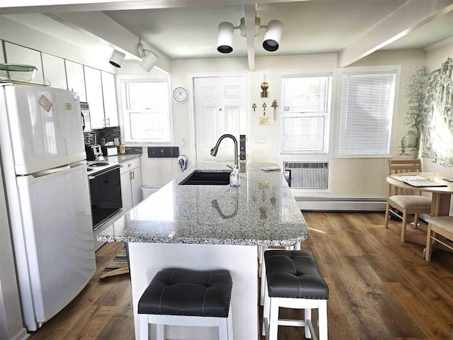 kitchen with a baseboard radiator, freestanding refrigerator, electric stove, white cabinetry, and a sink