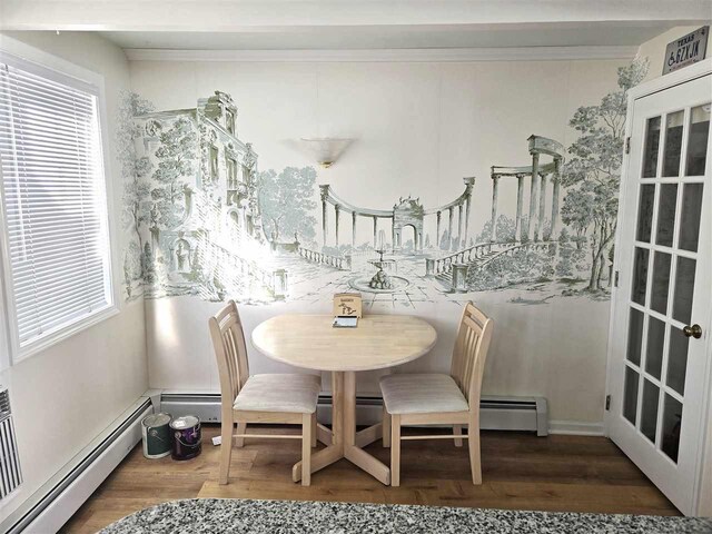 dining room featuring crown molding, wood finished floors, and baseboard heating