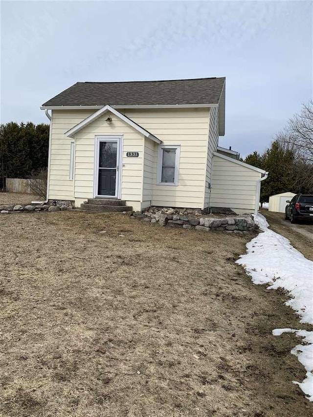 view of front of house featuring entry steps and roof with shingles