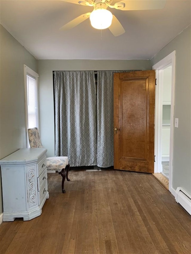 interior space featuring a baseboard radiator, a ceiling fan, and hardwood / wood-style floors