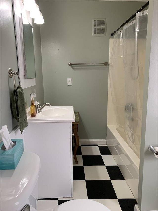 bathroom featuring vanity, baseboards, visible vents, tile patterned floors, and toilet