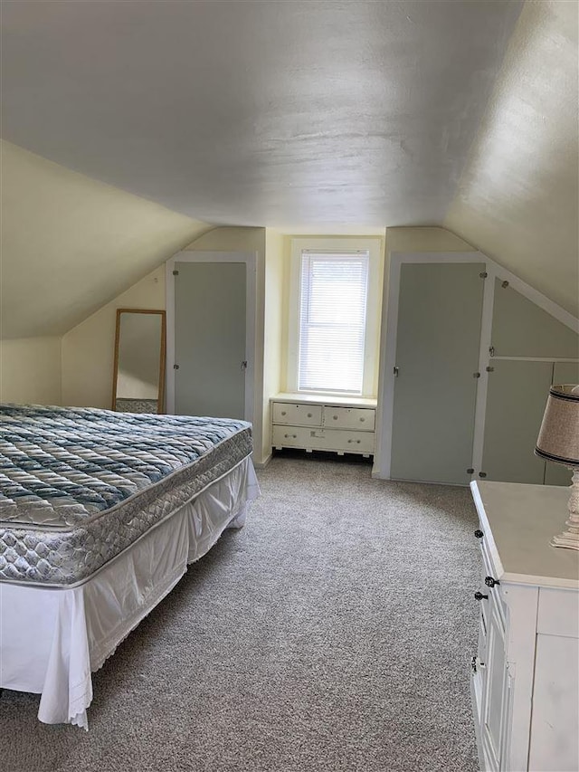 unfurnished bedroom featuring vaulted ceiling and carpet floors