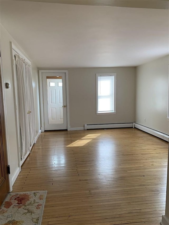 entrance foyer featuring a baseboard heating unit, baseboards, and wood finished floors