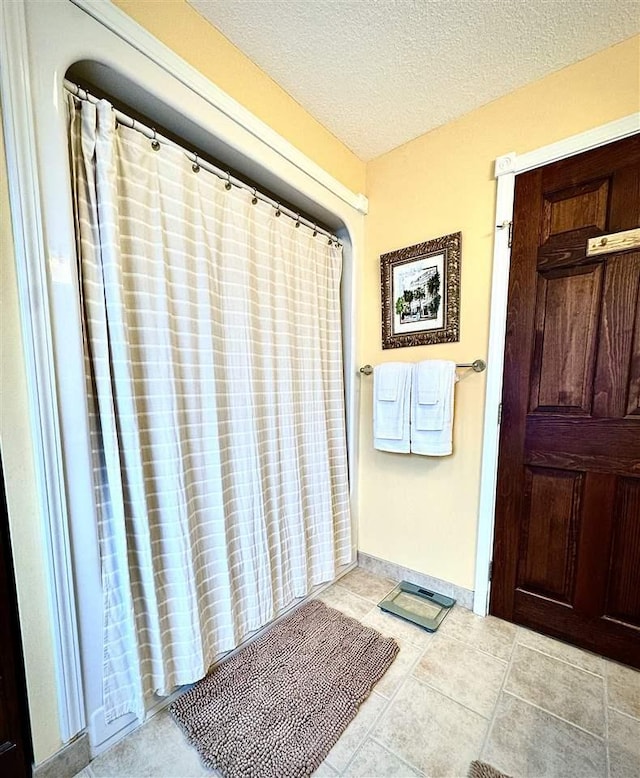 bathroom featuring baseboards and a textured ceiling