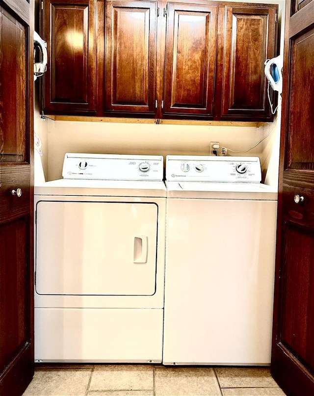 clothes washing area with washer and dryer and cabinet space