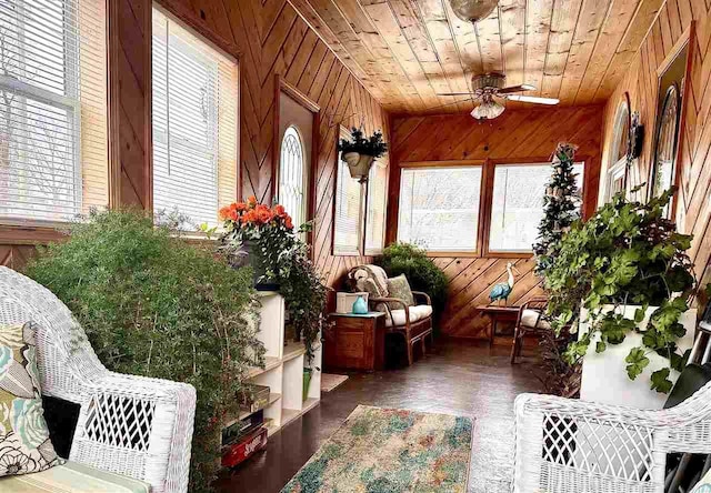 sunroom / solarium featuring wood ceiling and a ceiling fan