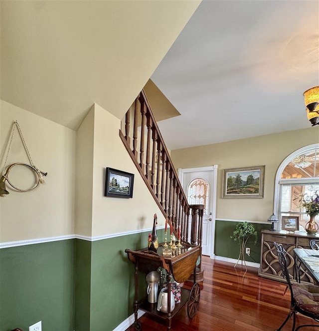 foyer featuring stairs, baseboards, and wood finished floors