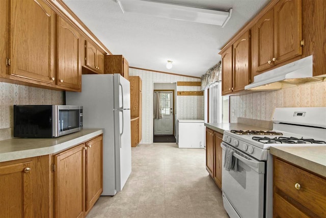 7116 S M-88 Hwy, Bellaire, MI 49615 - kitchen featuring wallpapered walls, brown cabinetry, under cabinet range hood, and white appliances