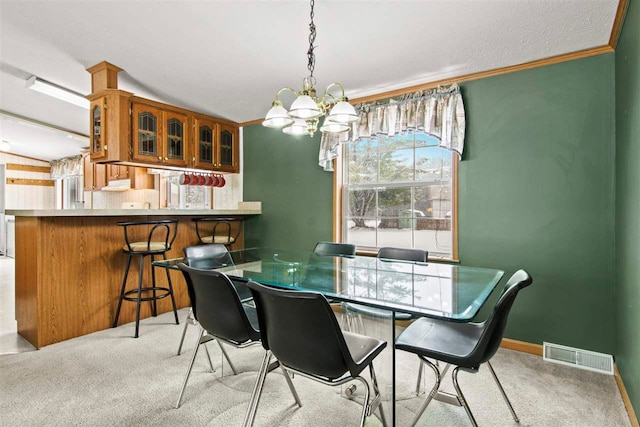 7116 S M-88 Hwy, Bellaire, MI 49615 - dining area featuring visible vents, baseboards, ornamental molding, a notable chandelier, and light colored carpet