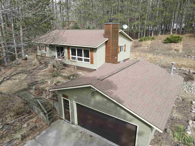 2382 Pleasant Valley Rd, Boyne City, MI 49712 - exterior space featuring a view of trees, a chimney, and a shingled roof