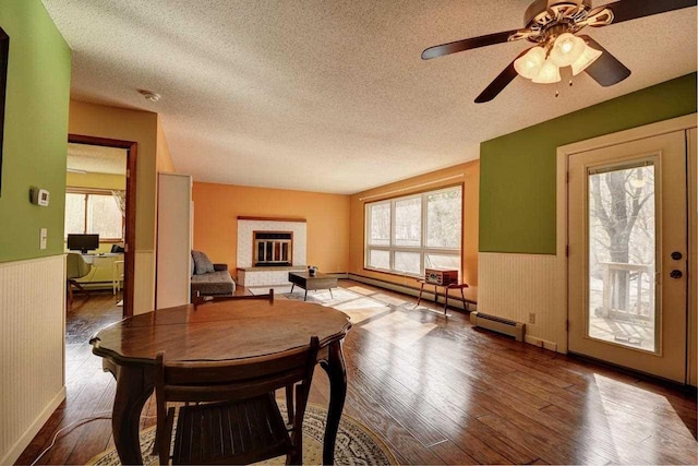 2382 Pleasant Valley Rd, Boyne City, MI 49712 - dining area with wood-type flooring, wainscoting, and a textured ceiling