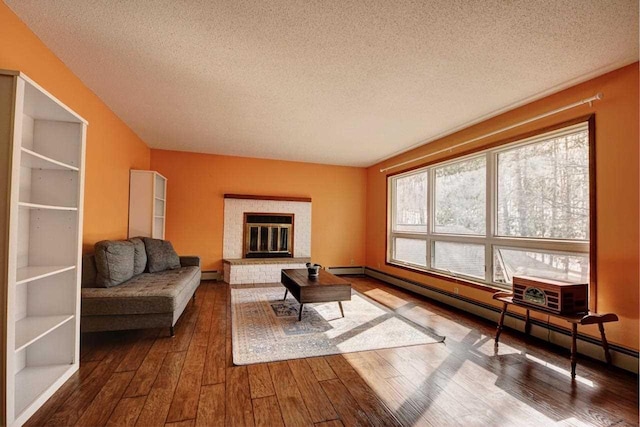 2382 Pleasant Valley Rd, Boyne City, MI 49712 - living room featuring a baseboard radiator, hardwood / wood-style flooring, and a textured ceiling