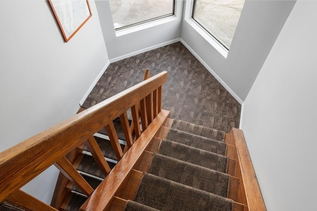staircase with baseboards and carpet floors
