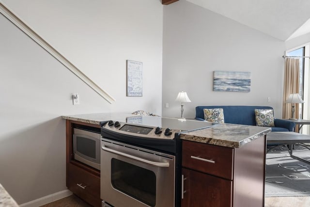 kitchen with a peninsula, appliances with stainless steel finishes, light countertops, lofted ceiling, and baseboards