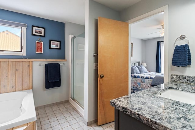 bathroom featuring a ceiling fan, ensuite bath, vanity, tile patterned flooring, and a stall shower