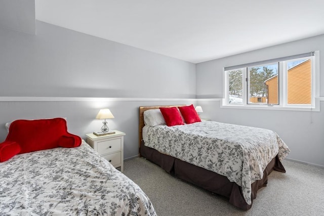 bedroom with light colored carpet and baseboards