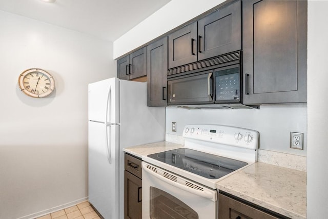 kitchen with light tile patterned floors, baseboards, black microwave, white electric range oven, and light stone counters