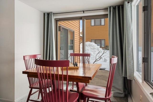 dining space with baseboards, carpet, and a healthy amount of sunlight
