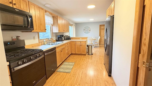 9196 NW Manley Rd, Alden, MI 49612 - kitchen with recessed lighting, a peninsula, light wood-style flooring, black appliances, and a sink