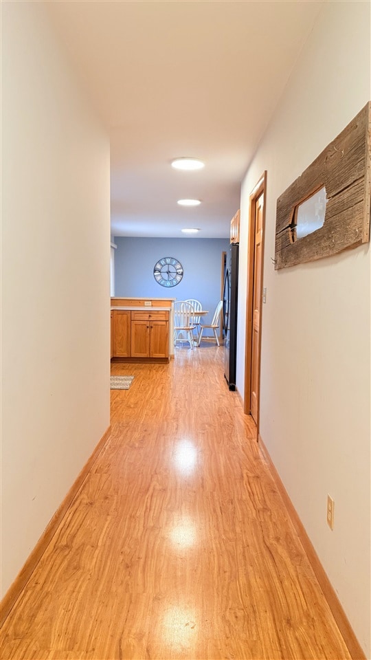 9196 NW Manley Rd, Alden, MI 49612 - hallway featuring light wood-style flooring and baseboards