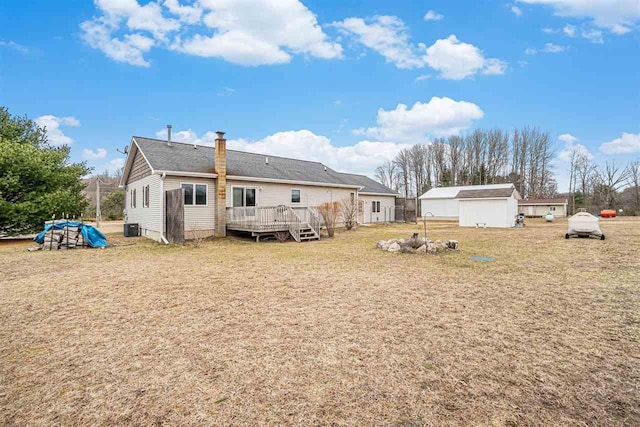 9196 NW Manley Rd, Alden, MI 49612 - back of house with a deck, a chimney, and an outbuilding