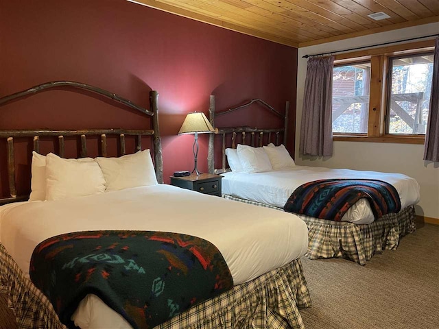 bedroom with wood ceiling, baseboards, and carpet