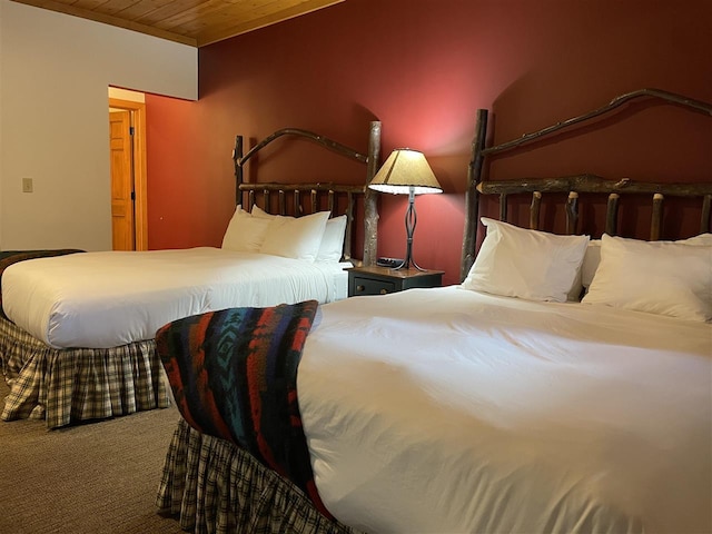 carpeted bedroom with wood ceiling