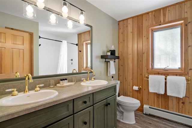 full bath featuring a baseboard heating unit, wood walls, a sink, and toilet