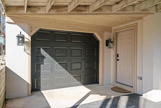 property entrance featuring a garage and stucco siding