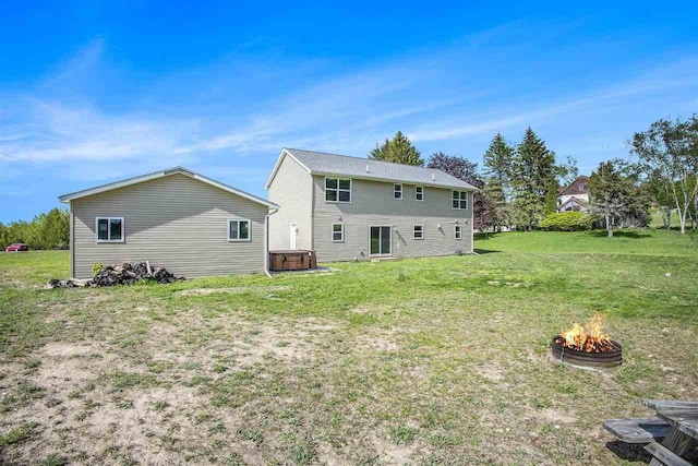 18180 Hilltop Dr, Charlevoix, MI 49720 - back of house with a covered hot tub, an outdoor fire pit, and a lawn