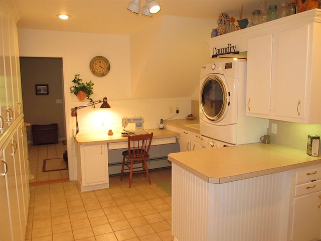 4251 Terpening Rd, Harbor Springs, MI 49740 - laundry room with a baseboard heating unit, light tile patterned flooring, stacked washing maching and dryer, cabinet space, and recessed lighting